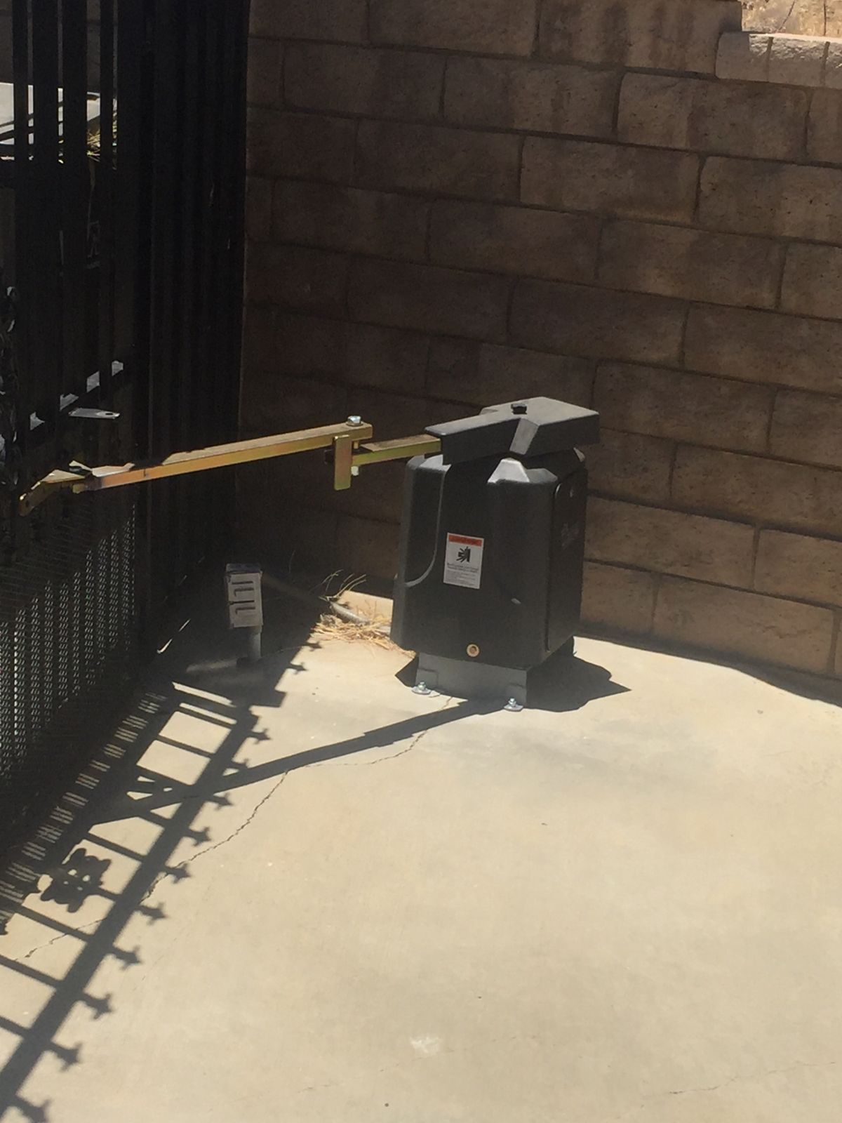 Swing gate operator arm on an iron gate