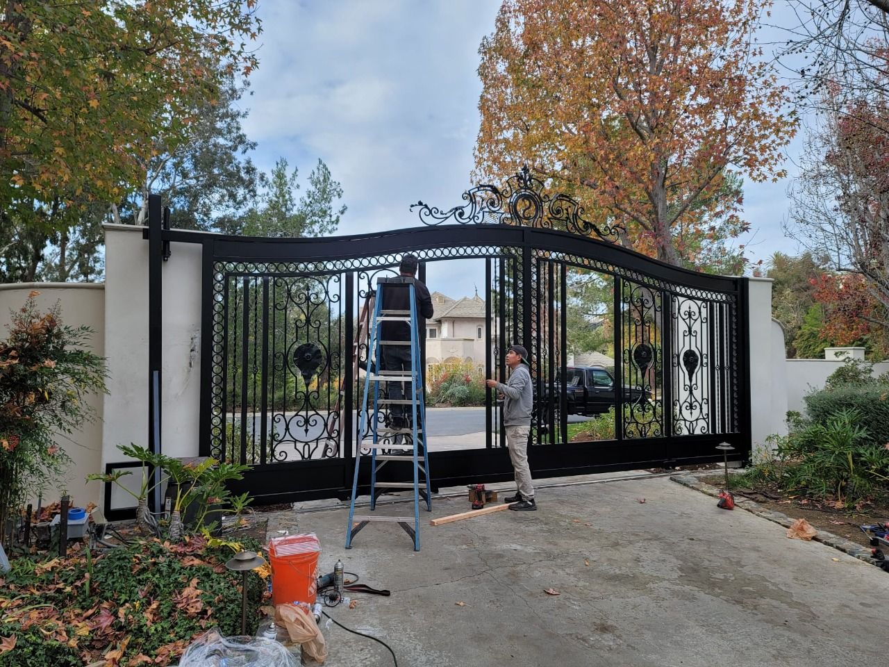 AER technicians working on a large iron driveway gate
